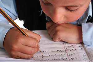 Ребенок пишет буквы в тетрадке